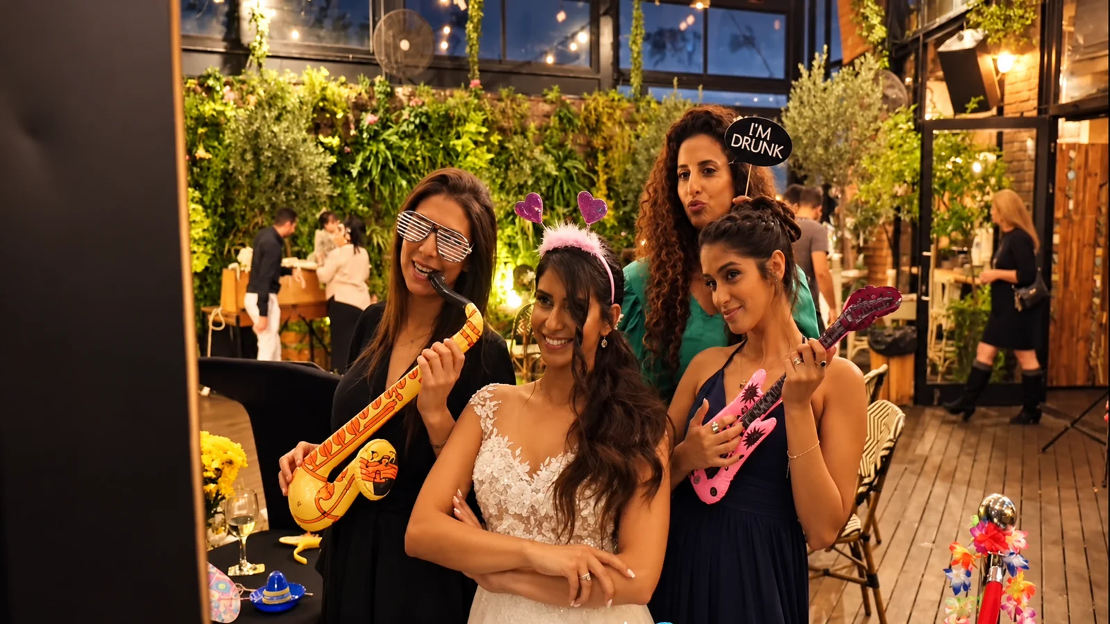 Guests celebrating together with colorful photo props at a garden party