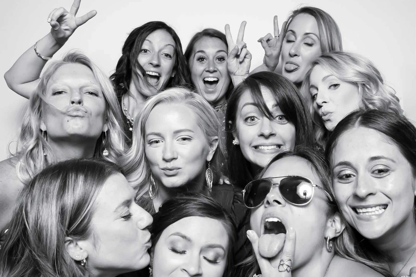 A lively group of guests smiling together in a black and white portrait