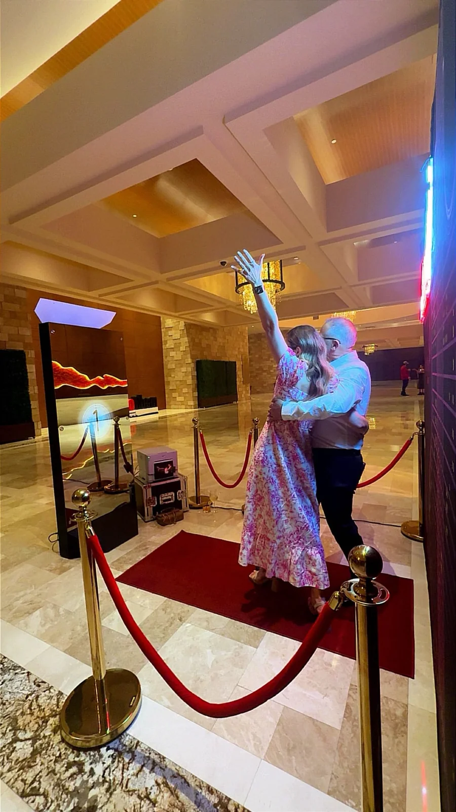 A guest exploring the mirror booth in a gold-accented venue