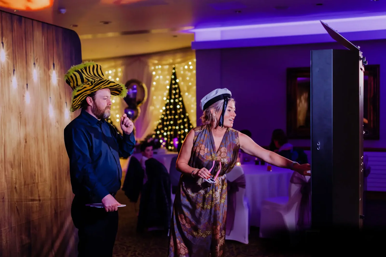 Guests using the photo booth during a warmly lit holiday celebration