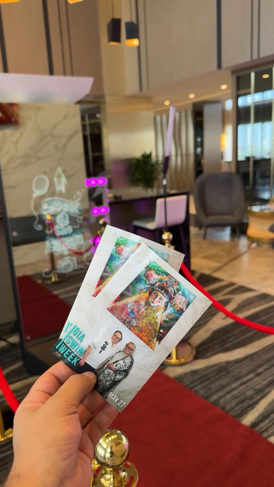 A hand holding photo prints in front of the Magic Mirror setup