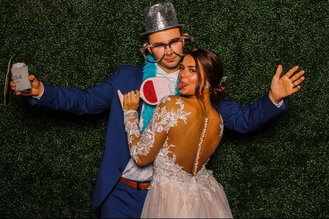 Bride and groom posing together with playful photo props