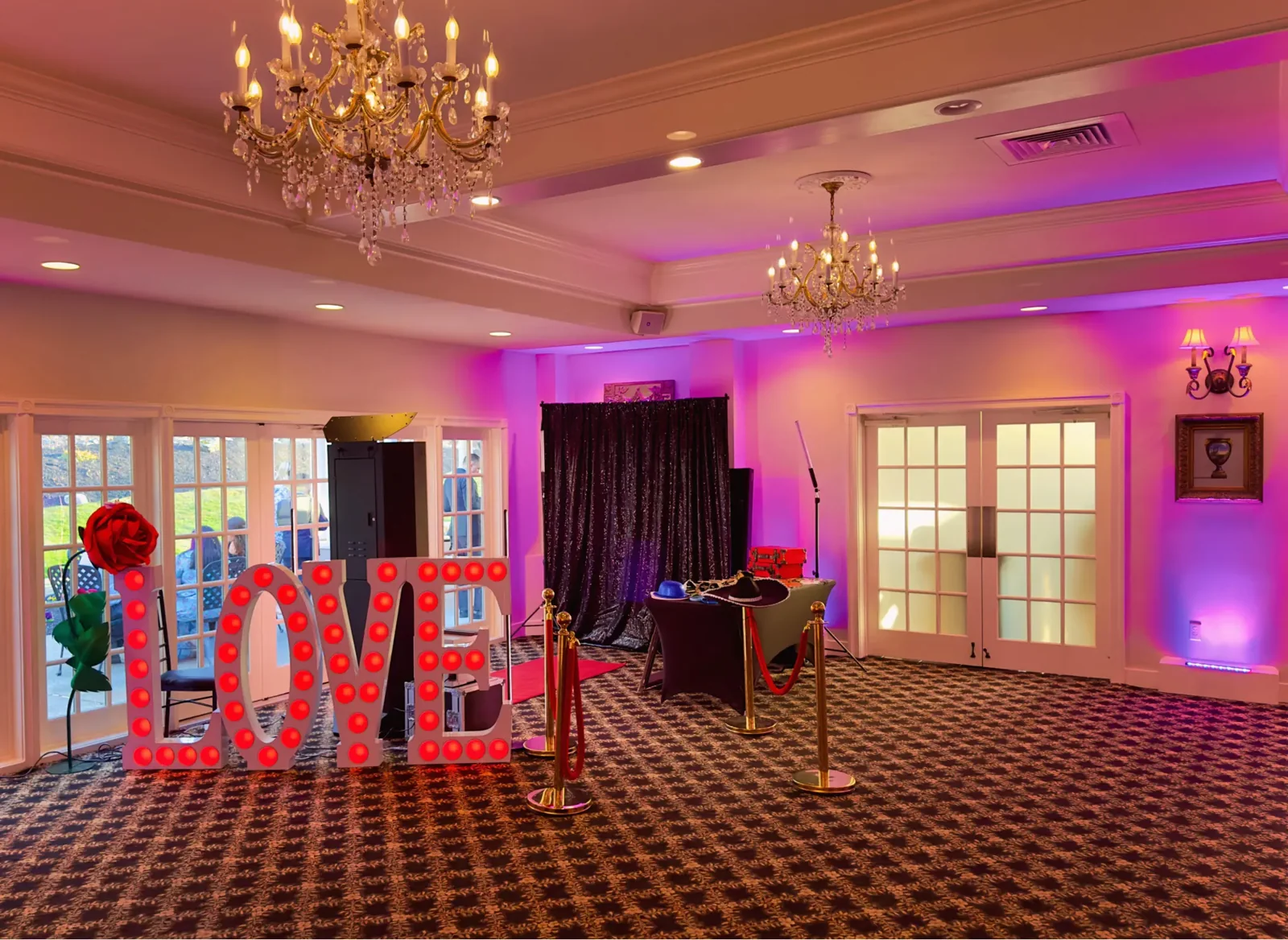 Wedding reception setup with illuminated LOVE letters and a photo booth